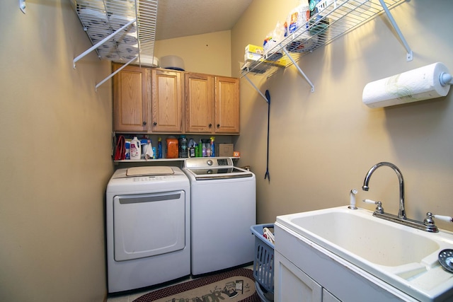 laundry room with cabinets, washer and dryer, and sink