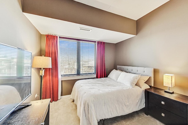 bedroom featuring multiple windows and light carpet