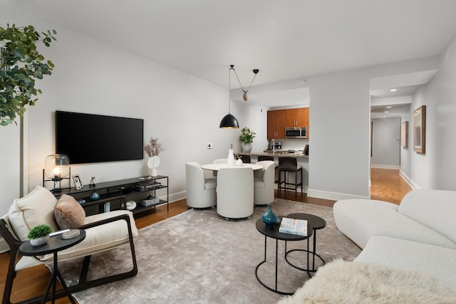 living room featuring recessed lighting, wood finished floors, and baseboards