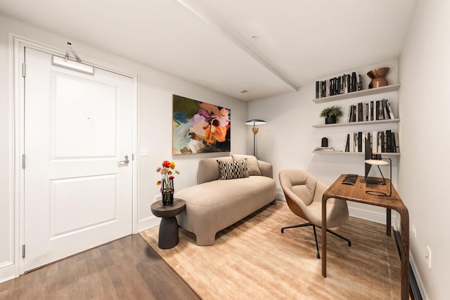 sitting room with baseboards and wood finished floors