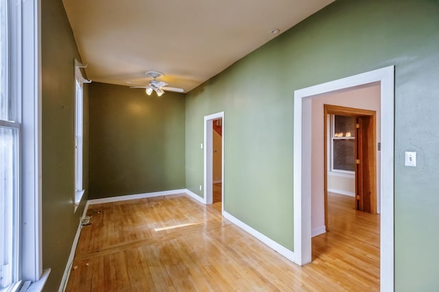 empty room with ceiling fan and light wood-type flooring