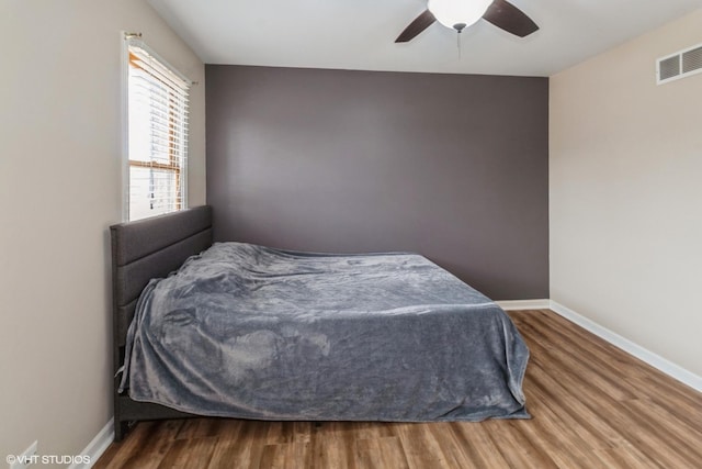 bedroom with ceiling fan and wood-type flooring