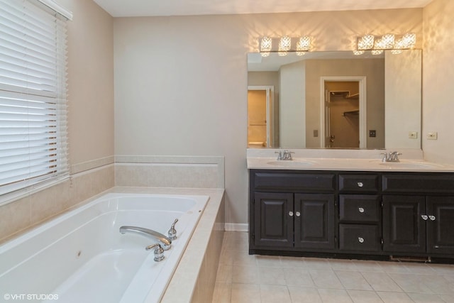 bathroom featuring vanity, a relaxing tiled tub, and tile patterned floors