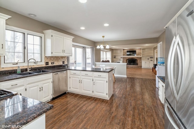 kitchen featuring hanging light fixtures, white cabinetry, appliances with stainless steel finishes, and kitchen peninsula