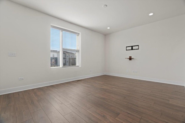 unfurnished room with dark wood-type flooring