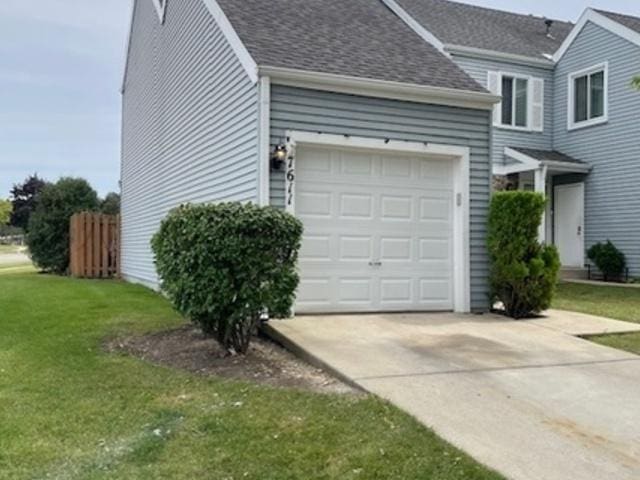 view of side of property with a garage and a lawn