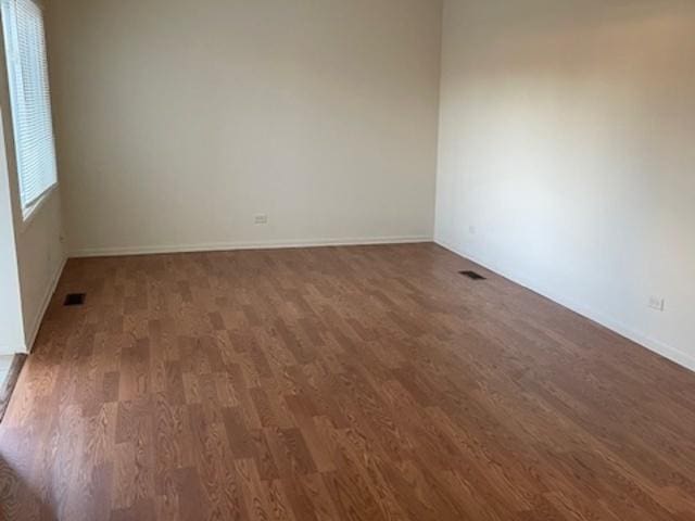 unfurnished room with dark wood-type flooring