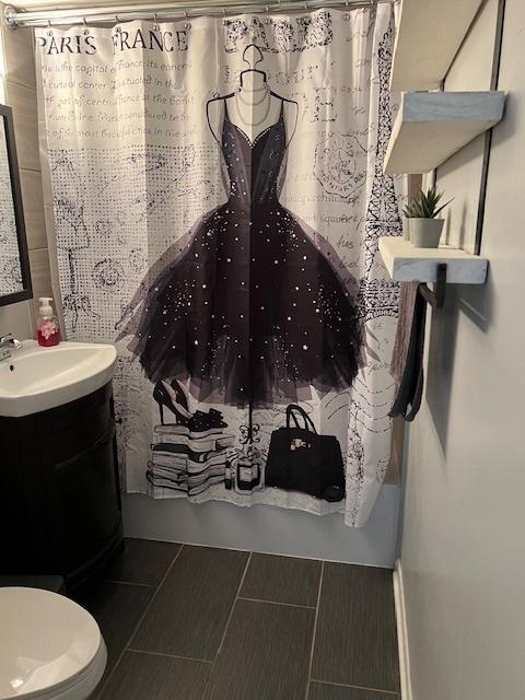 full bathroom with vanity, shower / bathtub combination with curtain, and toilet