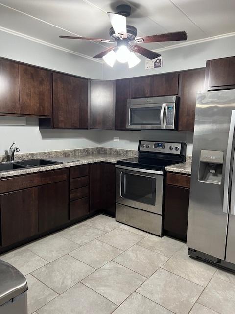 kitchen featuring stainless steel appliances, dark brown cabinets, sink, and ceiling fan