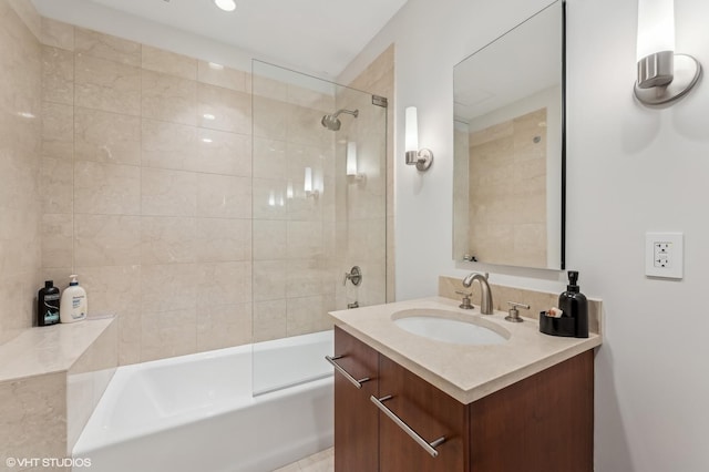 bathroom featuring tiled shower / bath and vanity