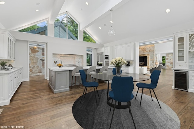 28 Brinker Rd, Barrington Hills, IL 60010 - dining space featuring wine cooler, healthy amount of natural light, beam ceiling, wood finished floors, and high vaulted ceiling