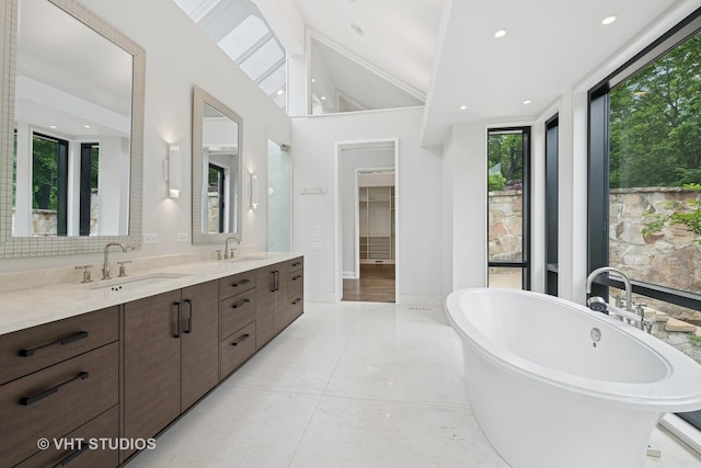 28 Brinker Rd, Barrington Hills, IL 60010 - bathroom featuring a freestanding bath, double vanity, lofted ceiling, and recessed lighting