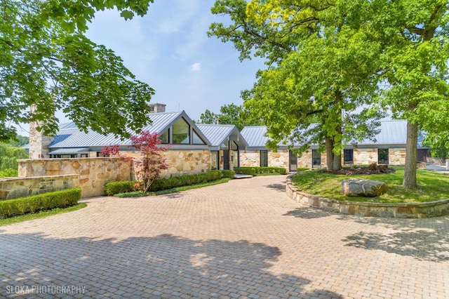 28 Brinker Rd, Barrington Hills, IL 60010 - view of front of property with a standing seam roof, stone siding, a metal roof, curved driveway, and a chimney