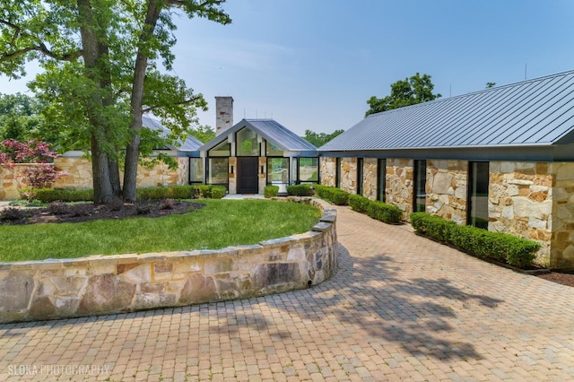 28 Brinker Rd, Barrington Hills, IL 60010 - view of front of home with a standing seam roof, stone siding, a metal roof, and a chimney
