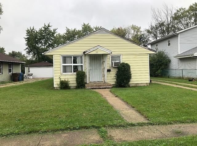 bungalow-style house featuring cooling unit and a front lawn