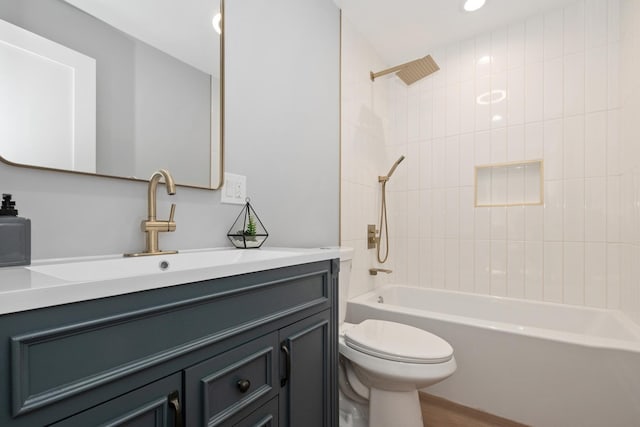 full bathroom with vanity, tiled shower / bath combo, and toilet