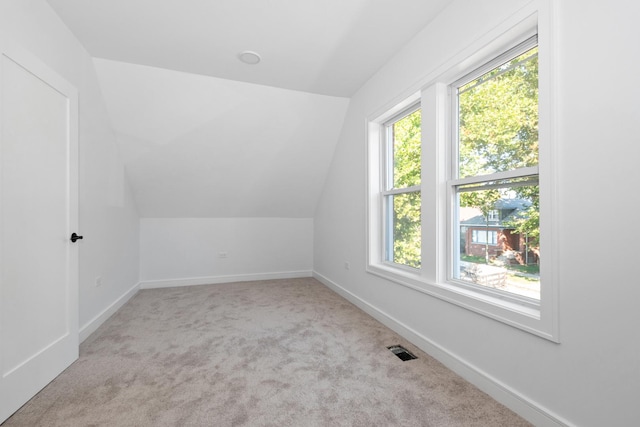 bonus room featuring lofted ceiling and light colored carpet