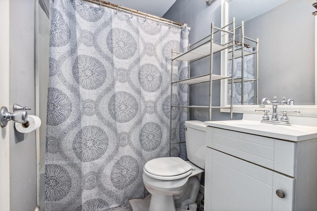 bathroom with curtained shower, vanity, and toilet