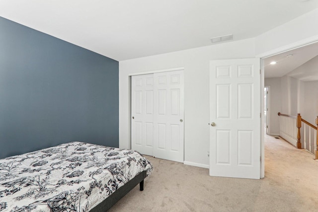 bedroom with light colored carpet and a closet