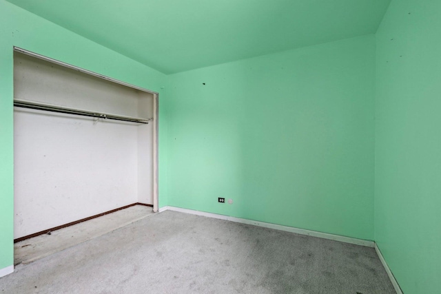 unfurnished bedroom featuring light carpet and a closet