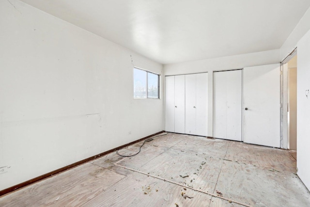 unfurnished bedroom featuring multiple closets