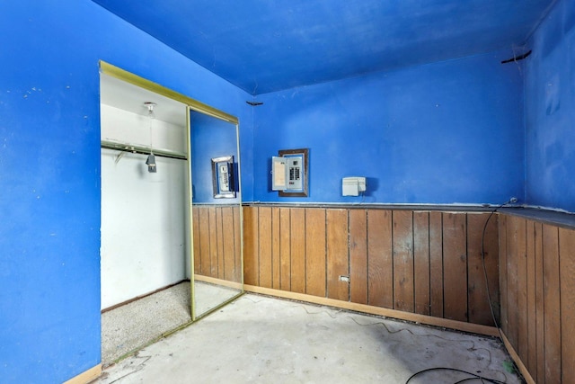 spare room featuring wooden walls and electric panel