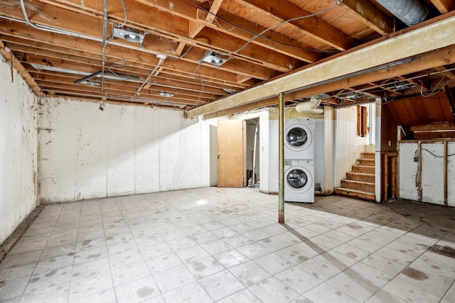 basement with stacked washer / drying machine