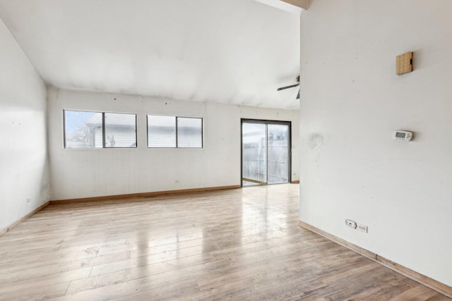 unfurnished room featuring lofted ceiling, a healthy amount of sunlight, and light hardwood / wood-style floors