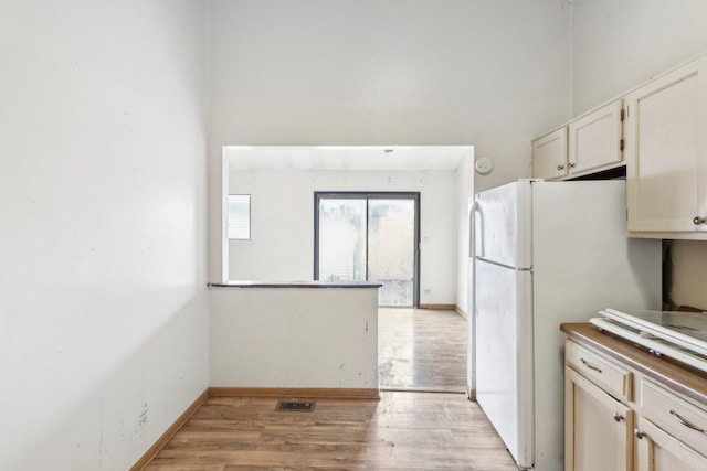 kitchen featuring white refrigerator and light hardwood / wood-style floors