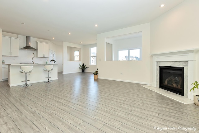 unfurnished living room with a premium fireplace and light hardwood / wood-style flooring