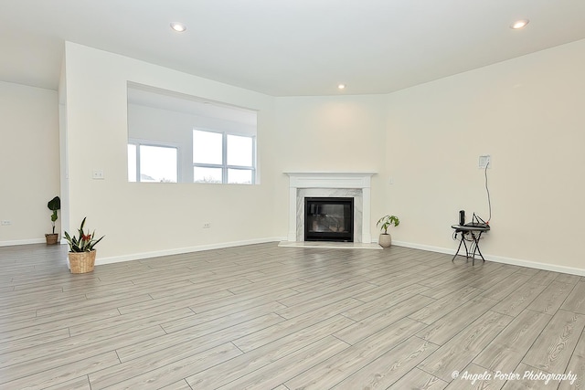 unfurnished living room featuring a fireplace and light hardwood / wood-style flooring