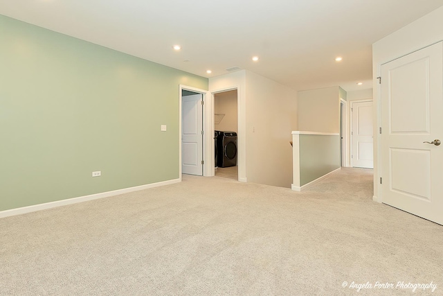 spare room with light colored carpet and washer / clothes dryer