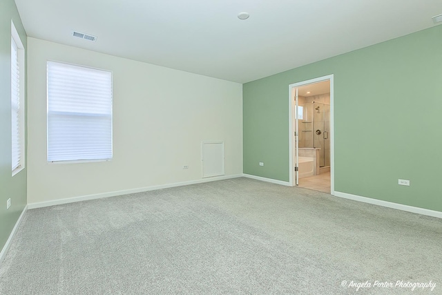 unfurnished room featuring light carpet