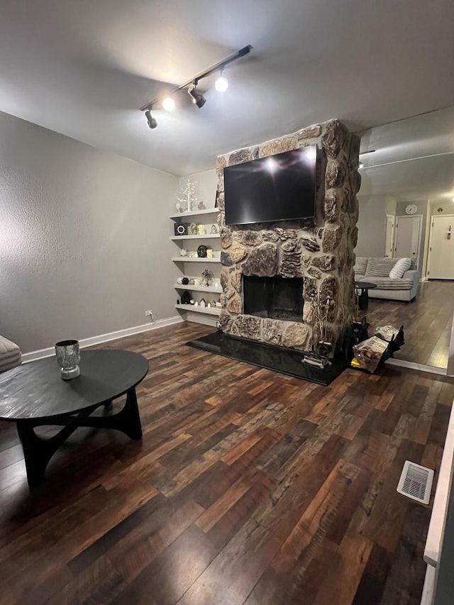 living room with a stone fireplace and hardwood / wood-style floors