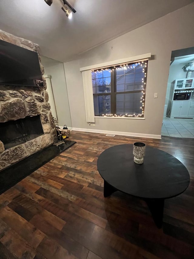 sitting room with hardwood / wood-style flooring, track lighting, lofted ceiling, and a fireplace