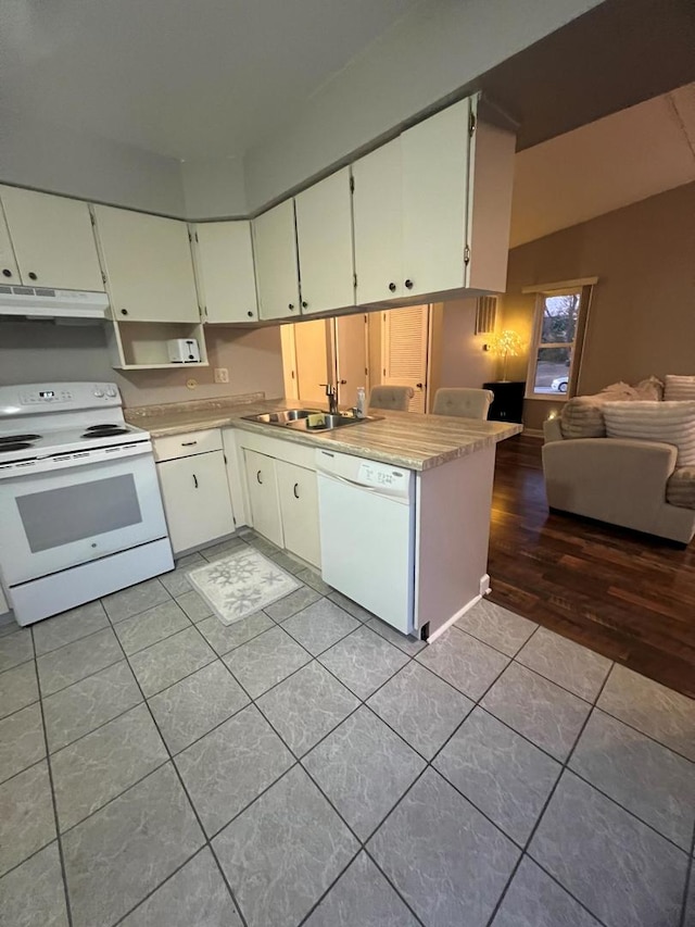 kitchen with white cabinetry, sink, light tile patterned floors, and white appliances