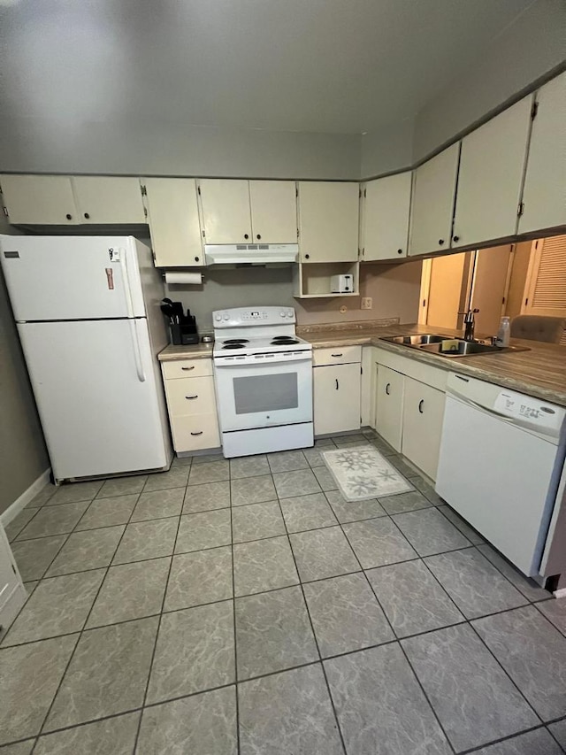 kitchen featuring white appliances, sink, and light tile patterned floors