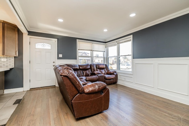 living room with crown molding and light hardwood / wood-style flooring