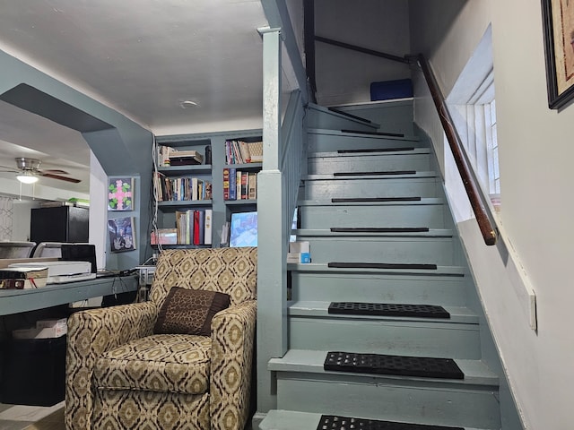 stairway with built in shelves and ceiling fan