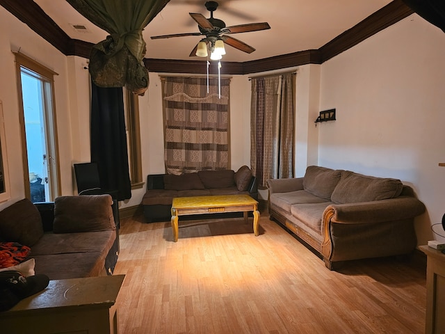 living room with ornamental molding, ceiling fan, and light wood-type flooring