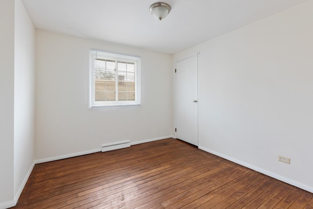 unfurnished room featuring a baseboard radiator and dark hardwood / wood-style flooring