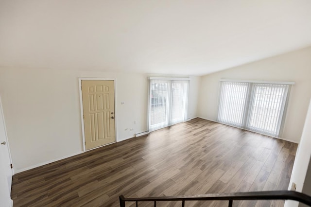 spare room featuring dark wood-type flooring and vaulted ceiling