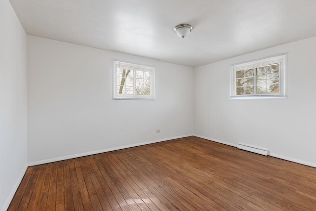 unfurnished room with a baseboard radiator, a healthy amount of sunlight, and hardwood / wood-style floors