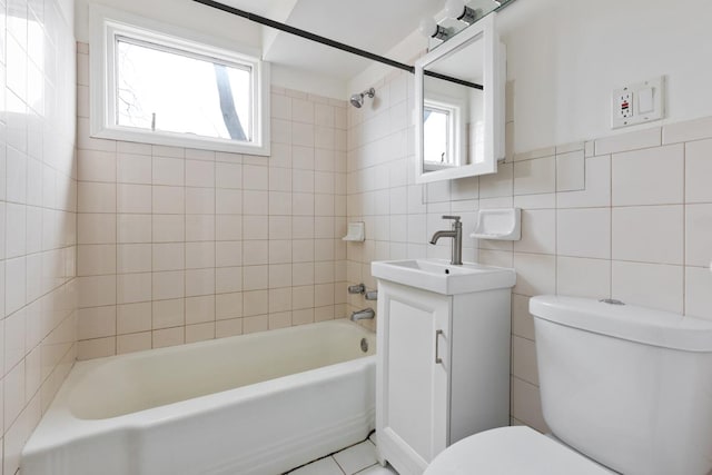 full bathroom with tile walls, tiled shower / bath combo, a wealth of natural light, and toilet