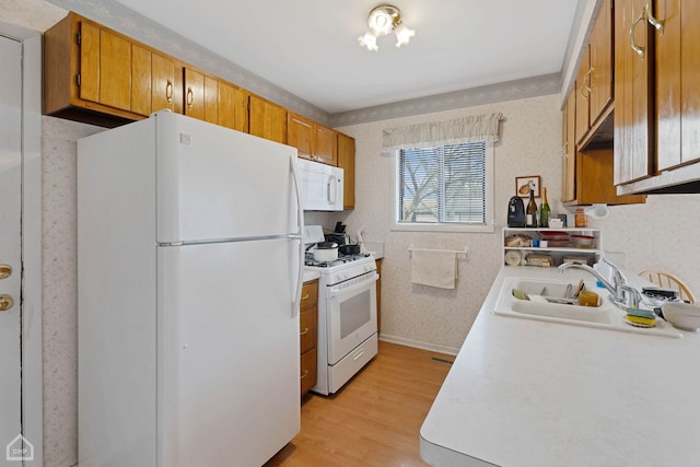 kitchen featuring sink, white appliances, and light hardwood / wood-style floors