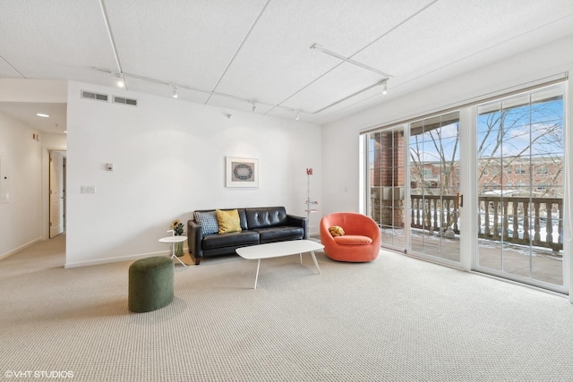 living room with baseboards, visible vents, carpet, a textured ceiling, and track lighting