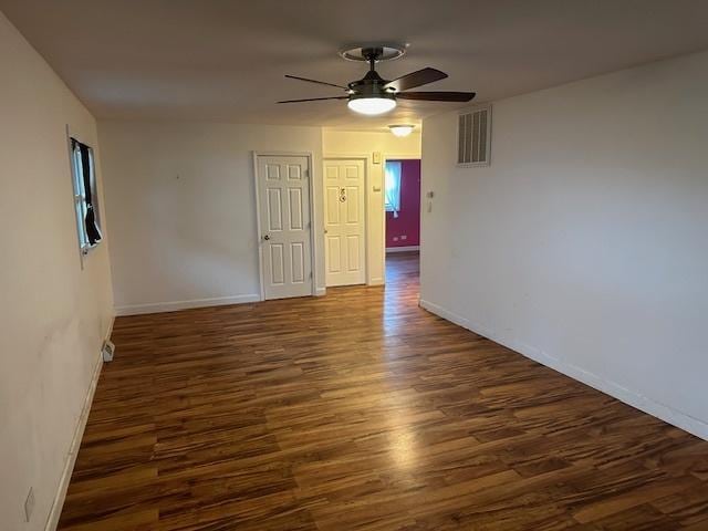 empty room with dark wood-type flooring and ceiling fan