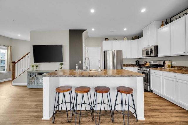 kitchen featuring appliances with stainless steel finishes, sink, and a kitchen island with sink