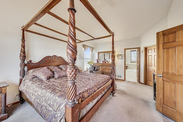 carpeted bedroom featuring lofted ceiling and ensuite bath