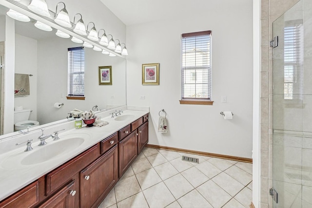 bathroom featuring an enclosed shower, vanity, tile patterned flooring, and toilet